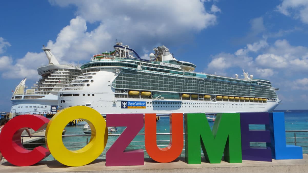 Cruise ship docked in front of sign in Cozumel
